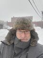 Self portrait (28 February 2025) @ 11:52 a.m. View to the northwest from the alley behind my home.